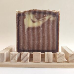 jabón de chocolate sobre jabonera de madera clara