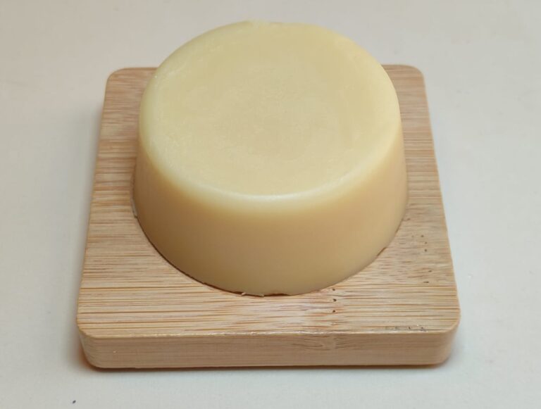 pastilla de crema sólida sobre jabonera de madera
