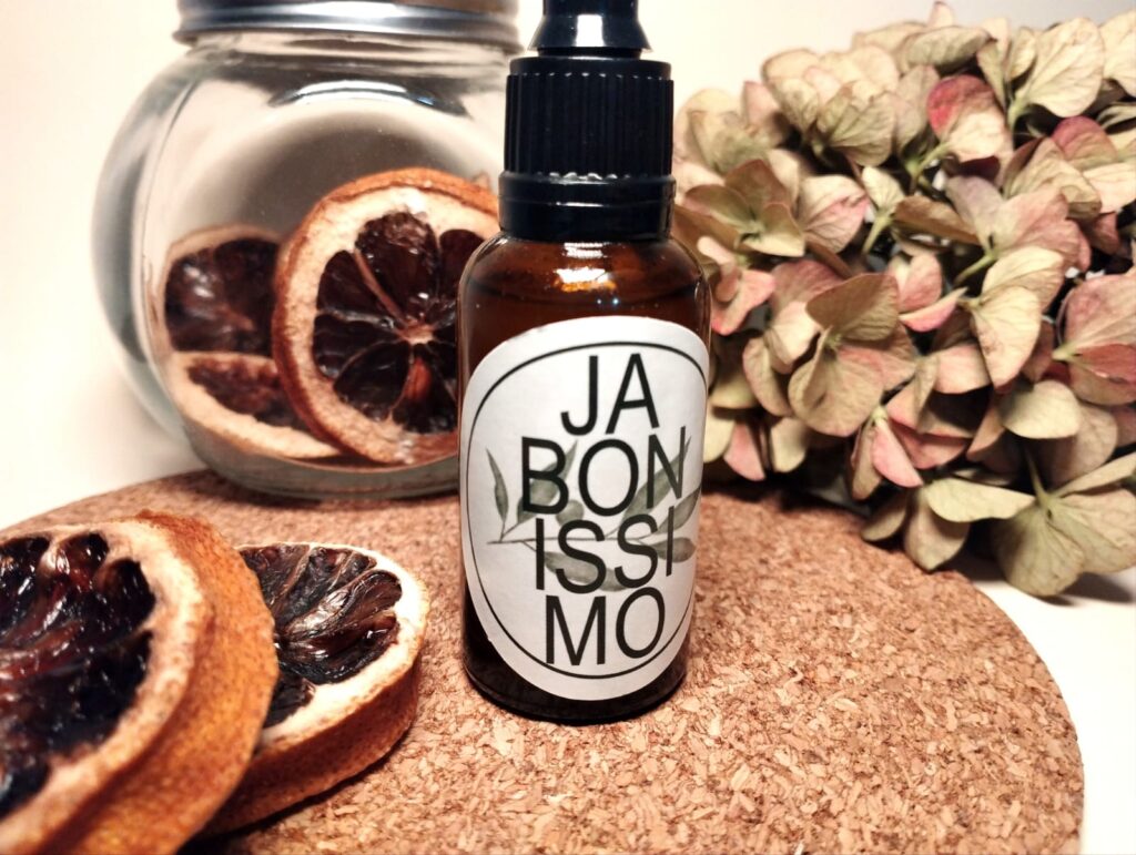 bote de serum pieles grasas con decorado de naranja y hortensias