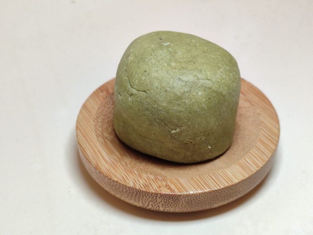 champú de neem y aloe vera sobre jabonera de madera sobre fondo claro